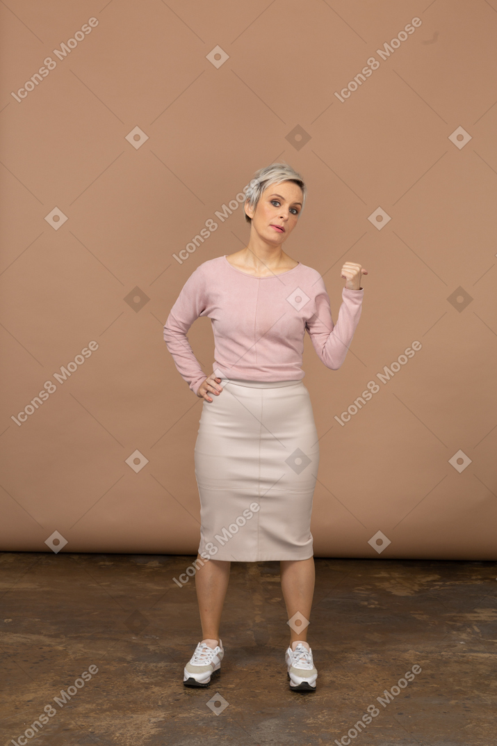 Vue de face d'une femme en vêtements décontractés pointant du doigt
