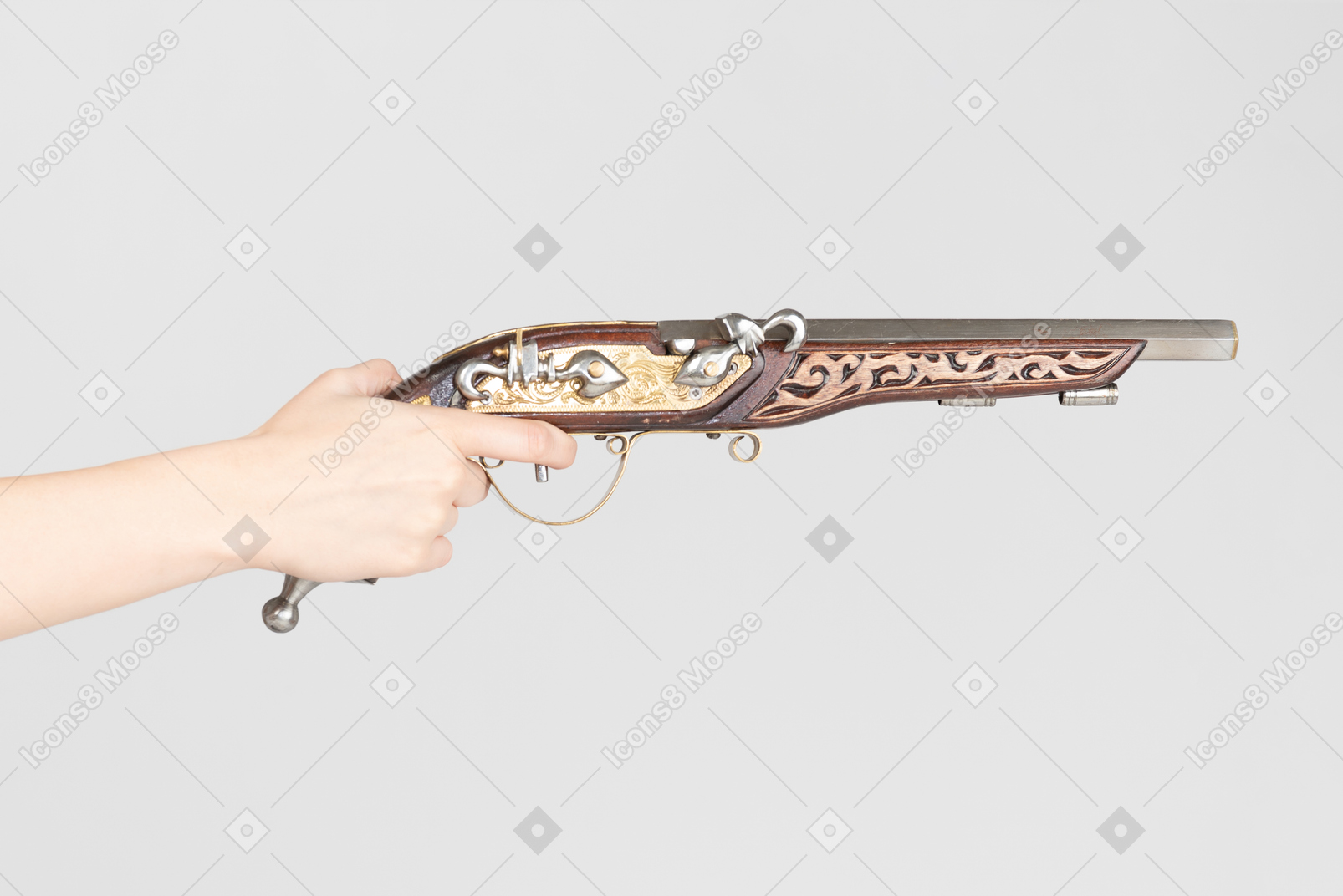 Mão feminina segurando pistola velha