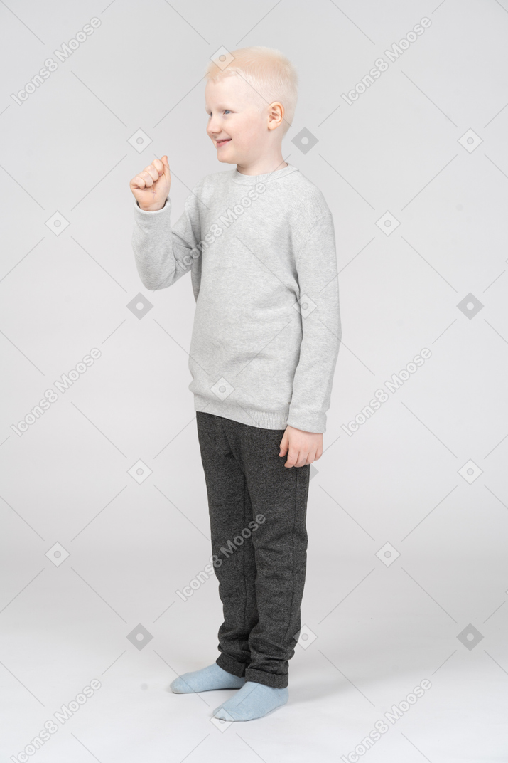 Little boy standing with his fist raised and smiling