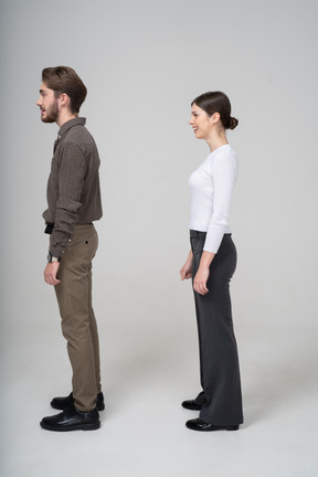 Side view of a confused smiling young couple in office clothing