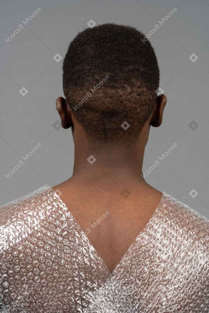 Cabeza a hombros espalda retrato de un hombre africano envuelto en plástico