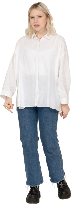 Vista frontale di una donna bionda in abiti casual che guarda l'obbiettivo e mostra il dito medio