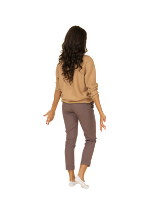 Three-quarter back view of a lost dark-skinned young female outspreading her hands