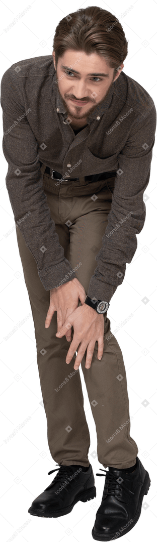 一个穿着办公室服装的年轻人触摸膝盖的前视图