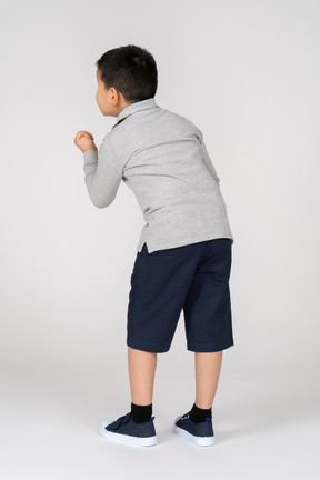 Rear view of a boy showing fist