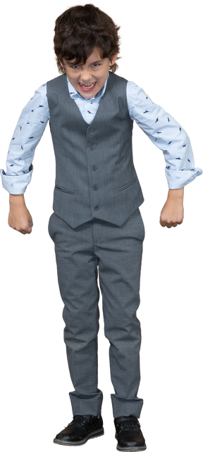 Vista frontal de un niño con traje gris asustando a alguien