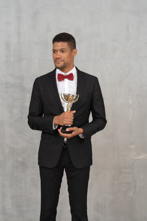 Smiling man in a suit holding an award