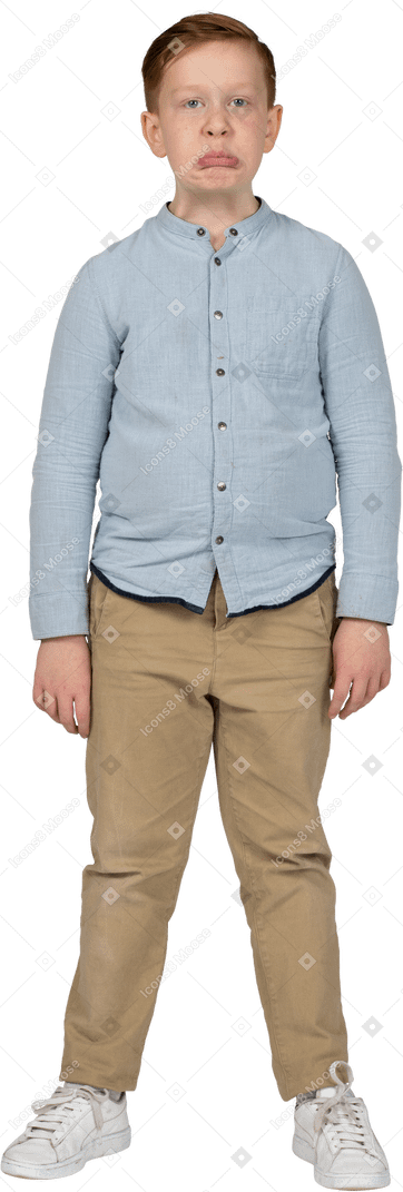 Vista frontal de um menino em roupas casuais fazendo caretas