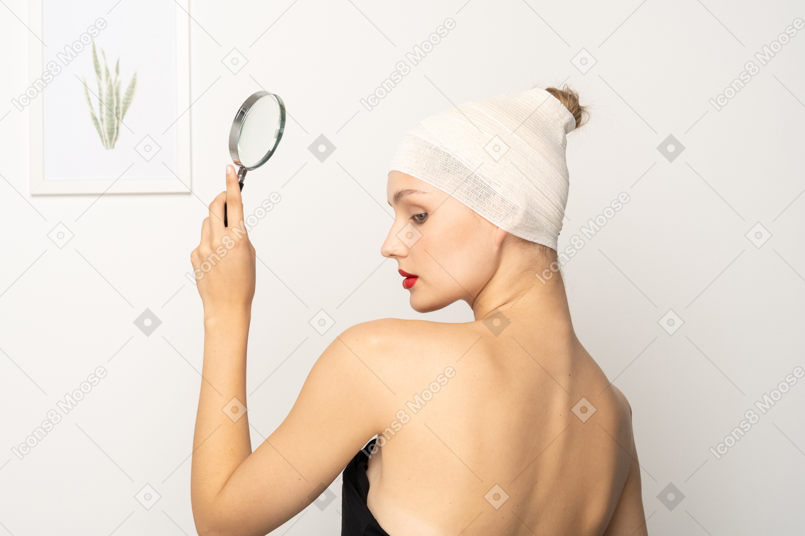 Young woman with bandaged head holding up magnifier