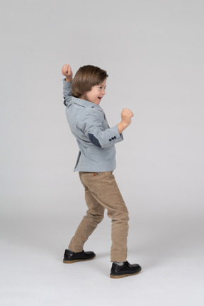An excited young boy in a figting pose