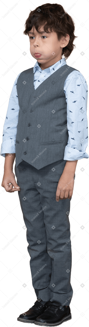 Vista frontal de un chico lindo en traje gris hinchando las mejillas