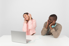 Attractive couple listening to music in headphones