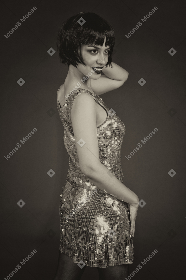 Delighted woman in sequin dress in the dark
