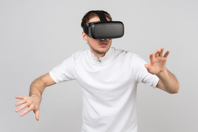 Jovem com fone de ouvido vr movendo-se cuidadosamente em algum lugar na realidade virtual