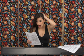 Shocked female pianist looking at musical notation