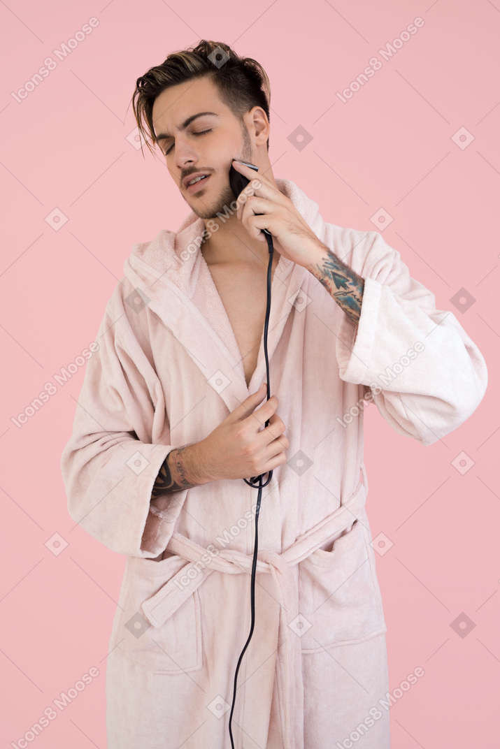 Handsome young man shaving his beard