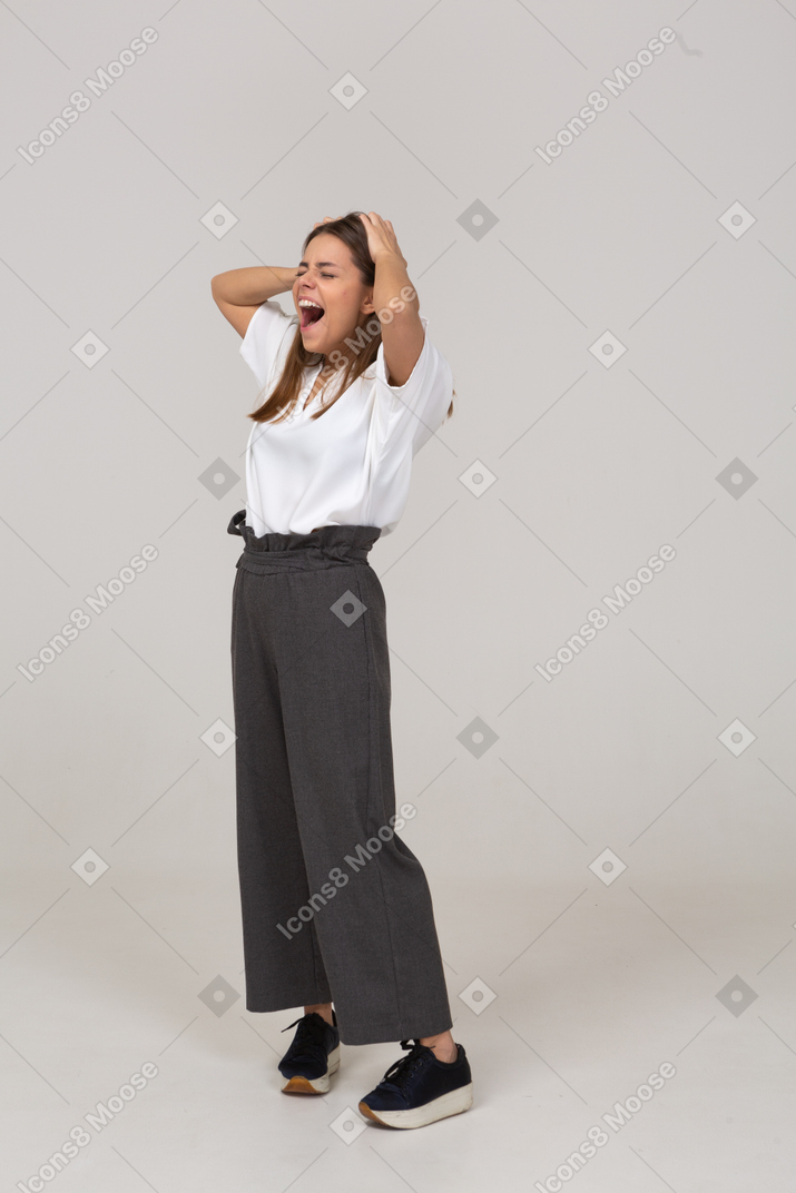 Three-quarter view of a yawning young lady in office clothing touching head