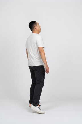 Side view of a man in casual clothes looking up