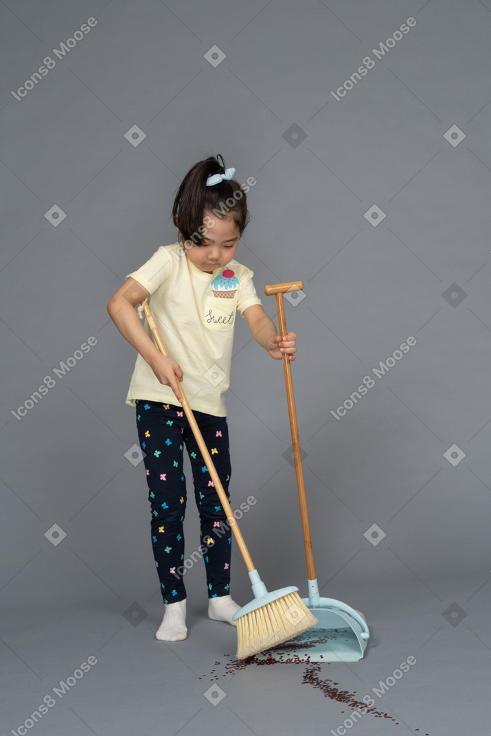 Front view of a little girl sweeping