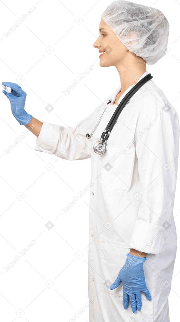Vista lateral de uma jovem médica com um estetoscópio segurando um termômetro