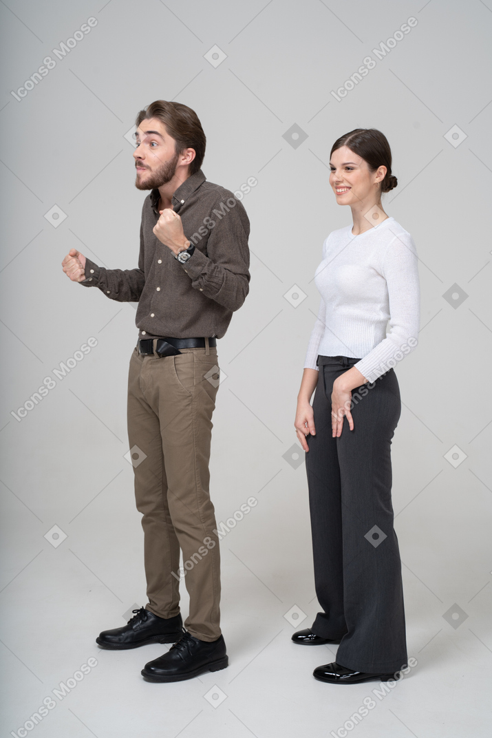 Three-quarter view of a delighted young woman and impatient man in office clothing