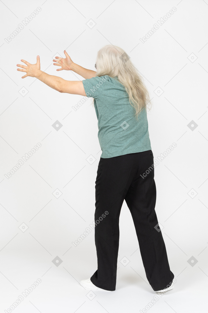 Three-quarter back view of old man pretending to hold something