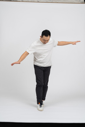 Vista frontal de un hombre con ropa informal caminando con los brazos extendidos
