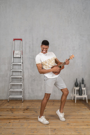 Three-quarter view of a man rocking out on ukulele