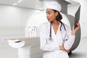 A female doctor standing next to an mri machine