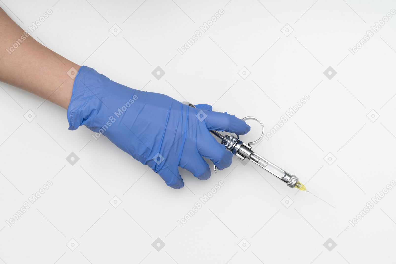 Mão na luva protetora segurando uma seringa
