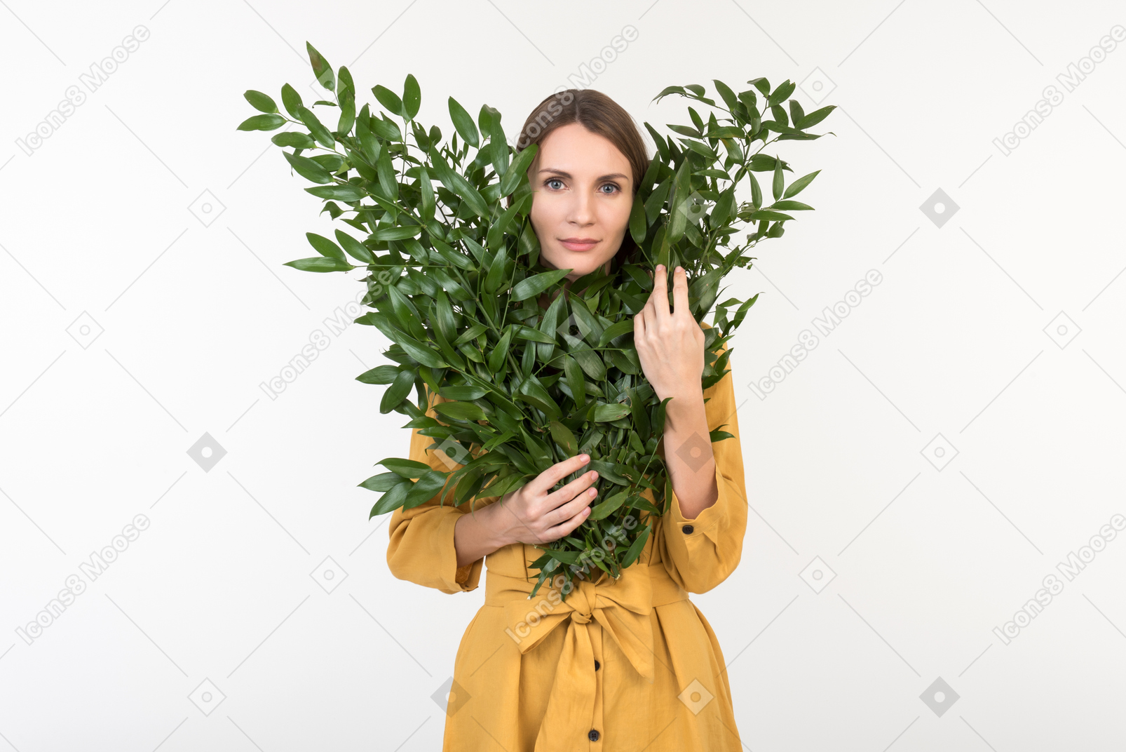 나뭇 가지에서 얼굴을 고집하는 젊은 여자