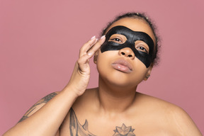 African-american woman using a black eye mask