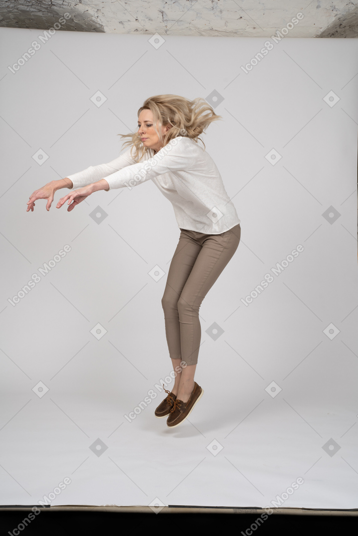Femme en vêtements décontractés sautant