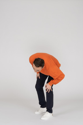 Jeune homme en sweat-shirt orange sautant