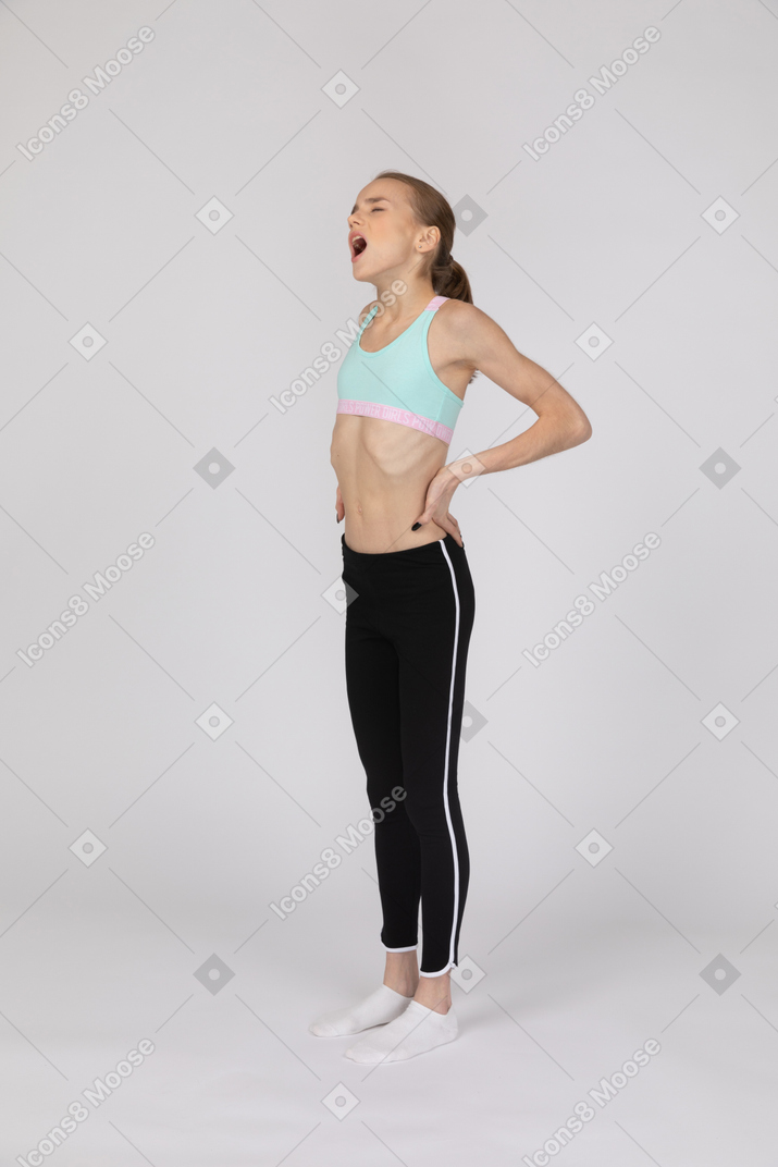 Девушка-подросток в спортивной одежде зевает