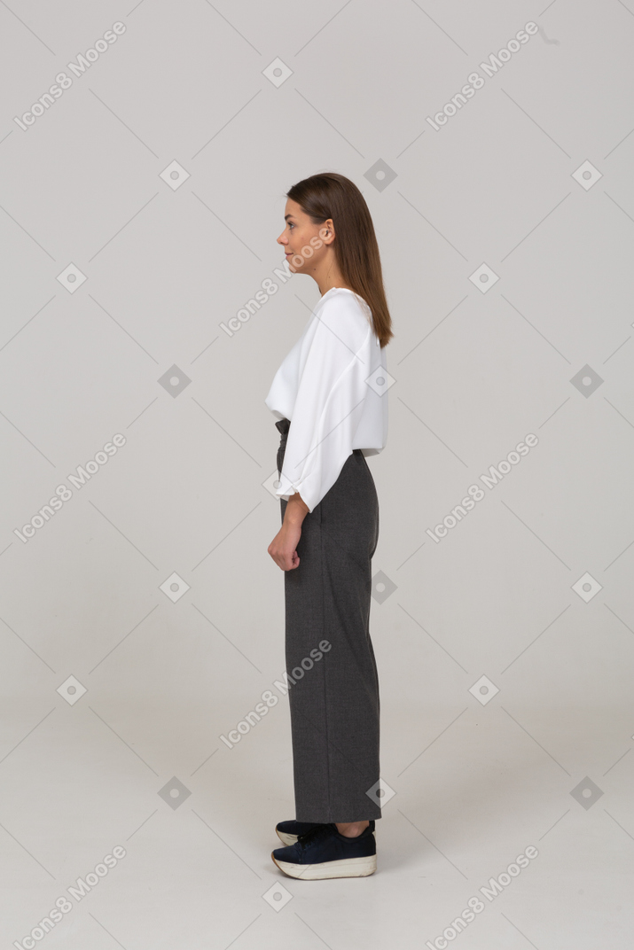 Vista lateral de una joven en ropa de oficina mirando a un lado