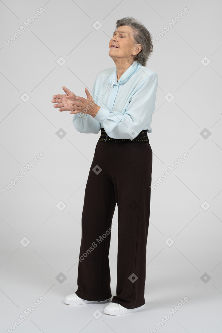 Anciana de pie con las manos extendidas
