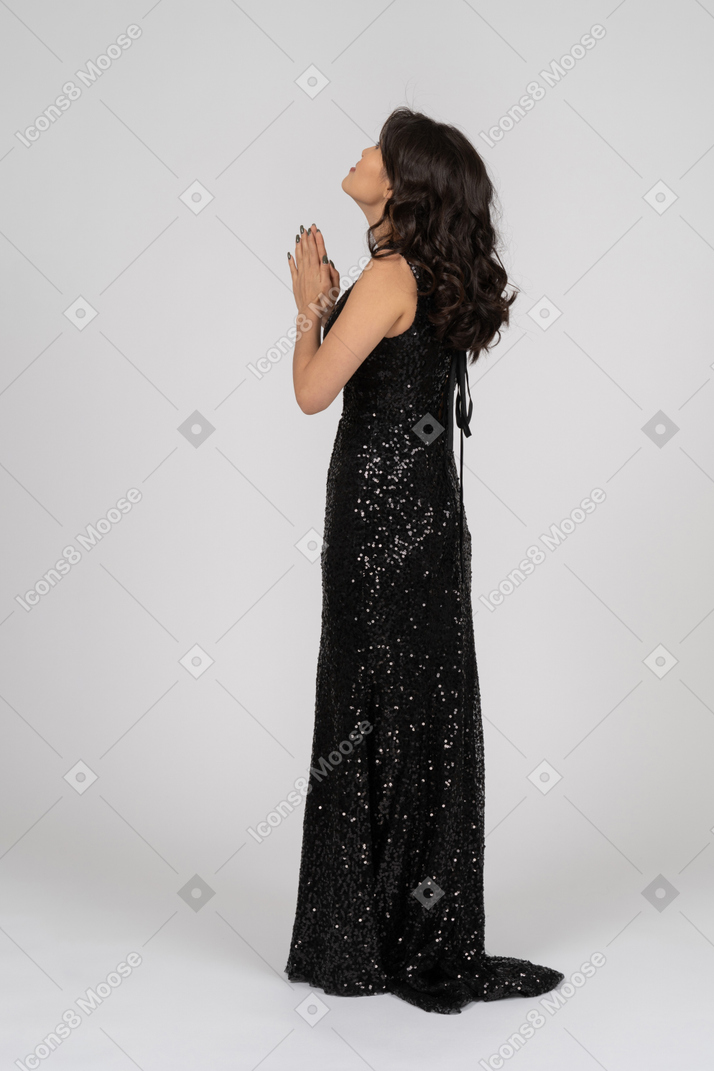 Молящаяся женщина в черном вечернем платье