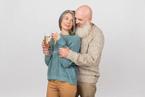 Элегантная пожилая пара пьет шампанское