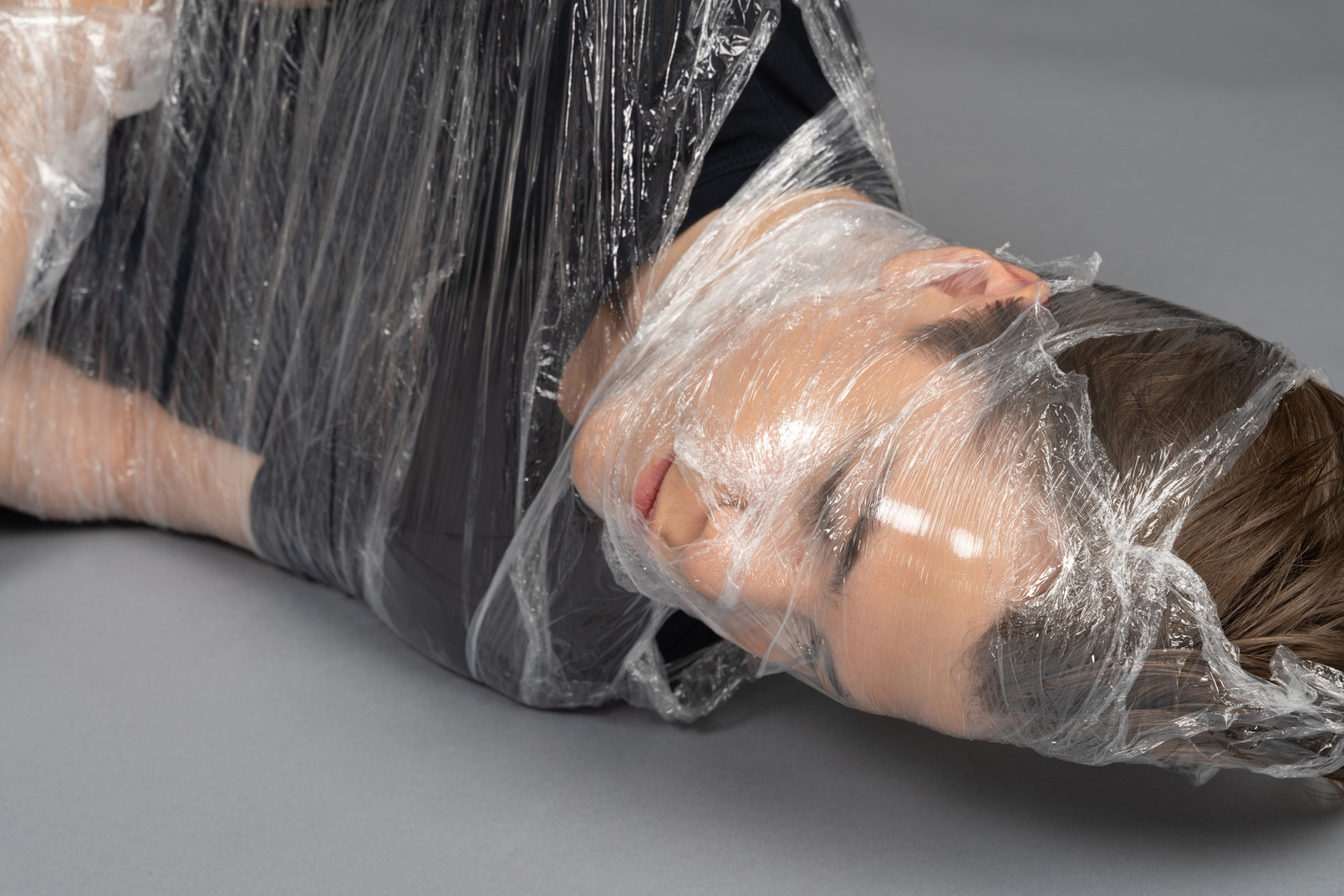Close up of a young man wrapped in plastic