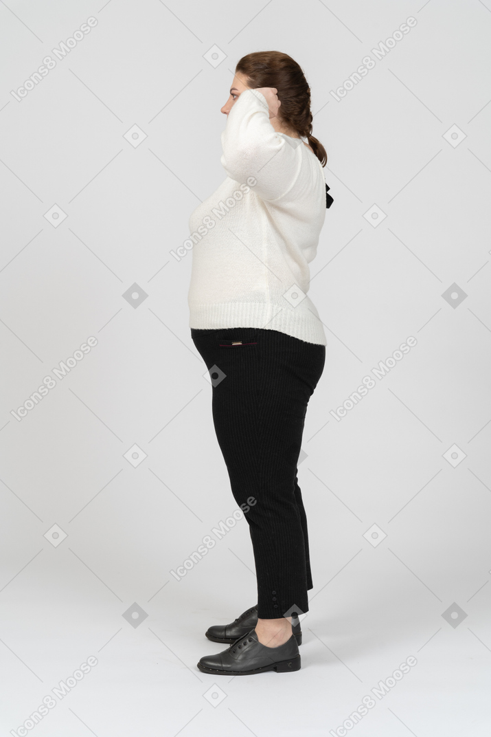 Plus size woman in casual clothes touching ears
