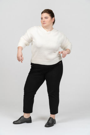 Serious plump woman in white sweater posing