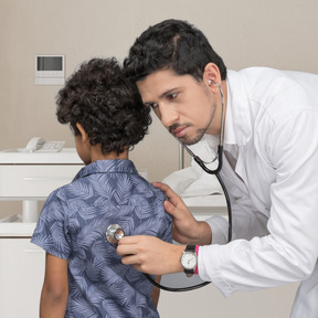 Doctor listening to boy with stethoscope