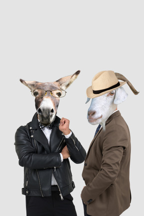 Anthropomorphic donkey and goat in suits standing next to each other