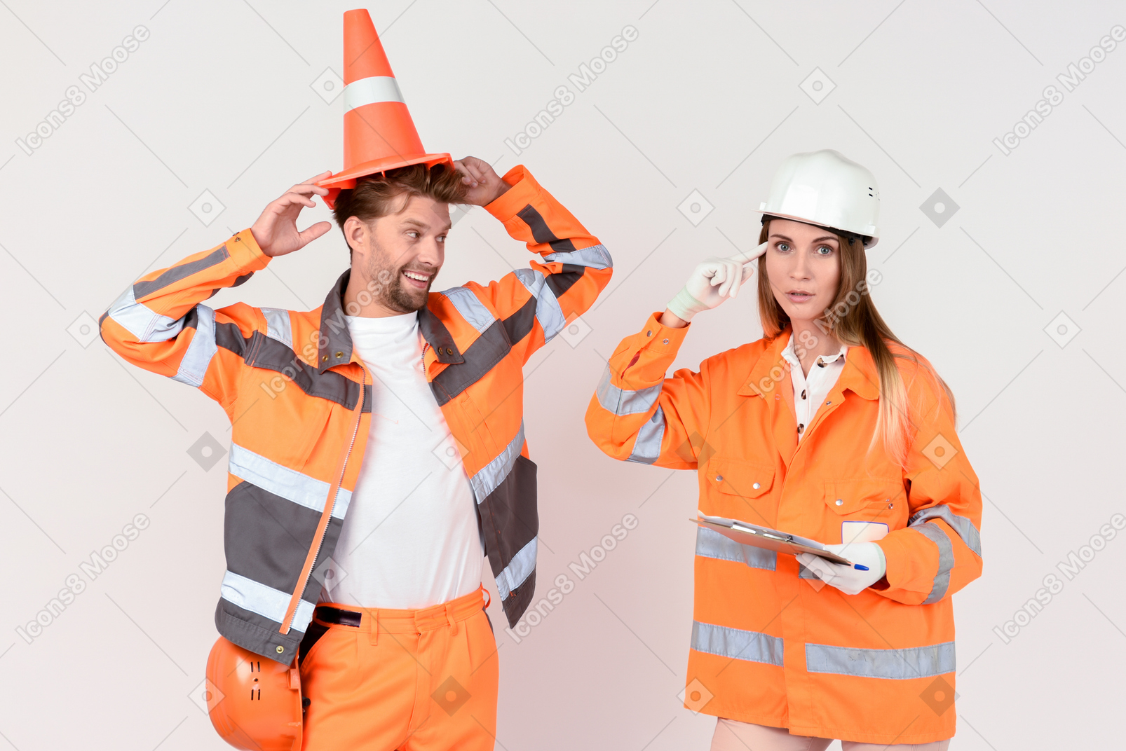 Male road worker putting on a cone and his female colleague showing that he's a dummy