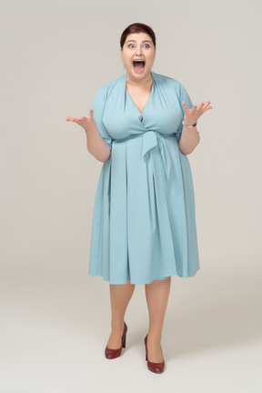 Vista frontal de uma mulher impressionada em um vestido azul