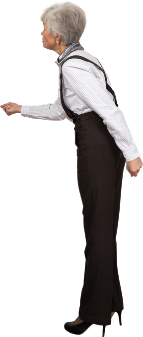 Vista lateral de uma senhora zangada com roupas de escritório estendendo a mão