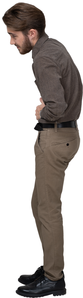 Side view of a young man in office clothing touching stomach