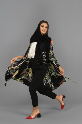 Happy middle eastern woman walking sideways