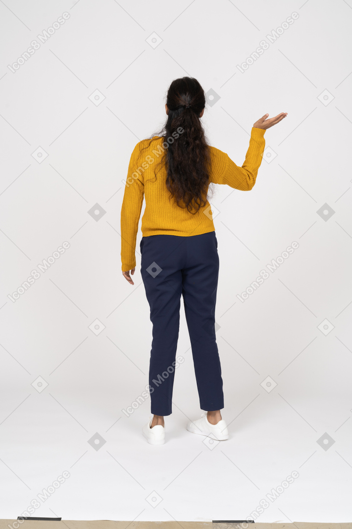 Rear view of a girl in casual clothes waving